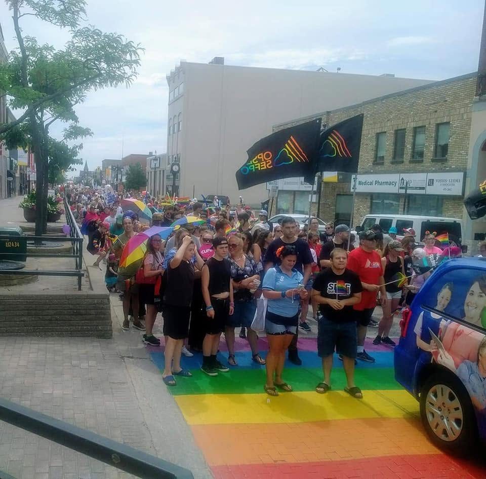 North Bay Pride participants crossing a rainbow crosswalk during the parade